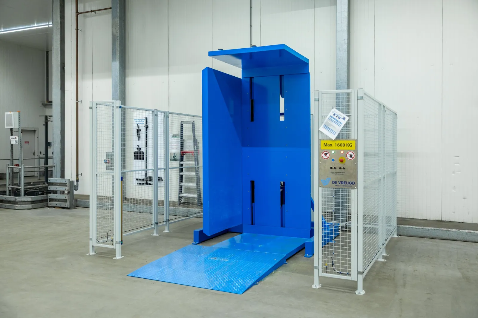 Volteador de palets PalletRotator K13 EPT con rampa y valla de protección en una cámara frigorífica
